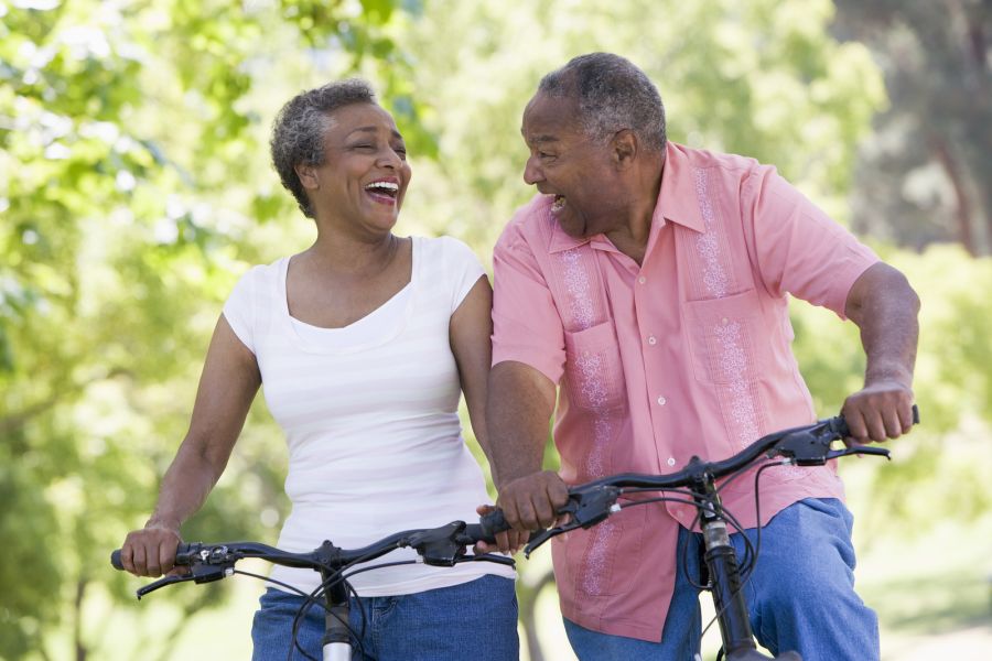 older man and woman riding bikes and laughing